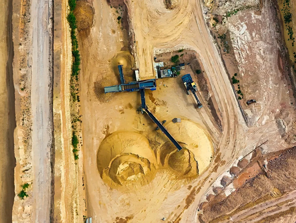 Aerial view of conveyors, machinery and stockpiles at a mining site